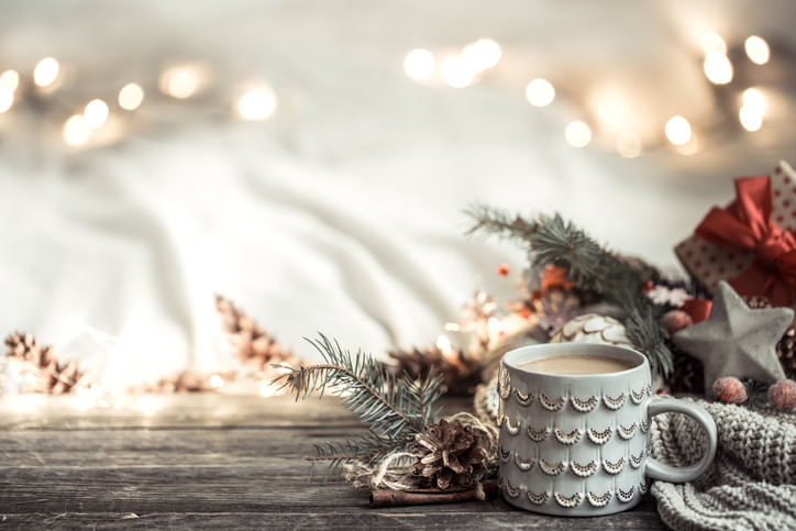 Coffee mug up against holiday décor and lights