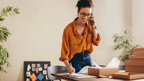 A woman on the phone filling out paperwork