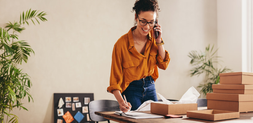 A woman on the phone filling out paperwork