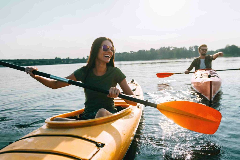 A woman and man kayaking on a lake.