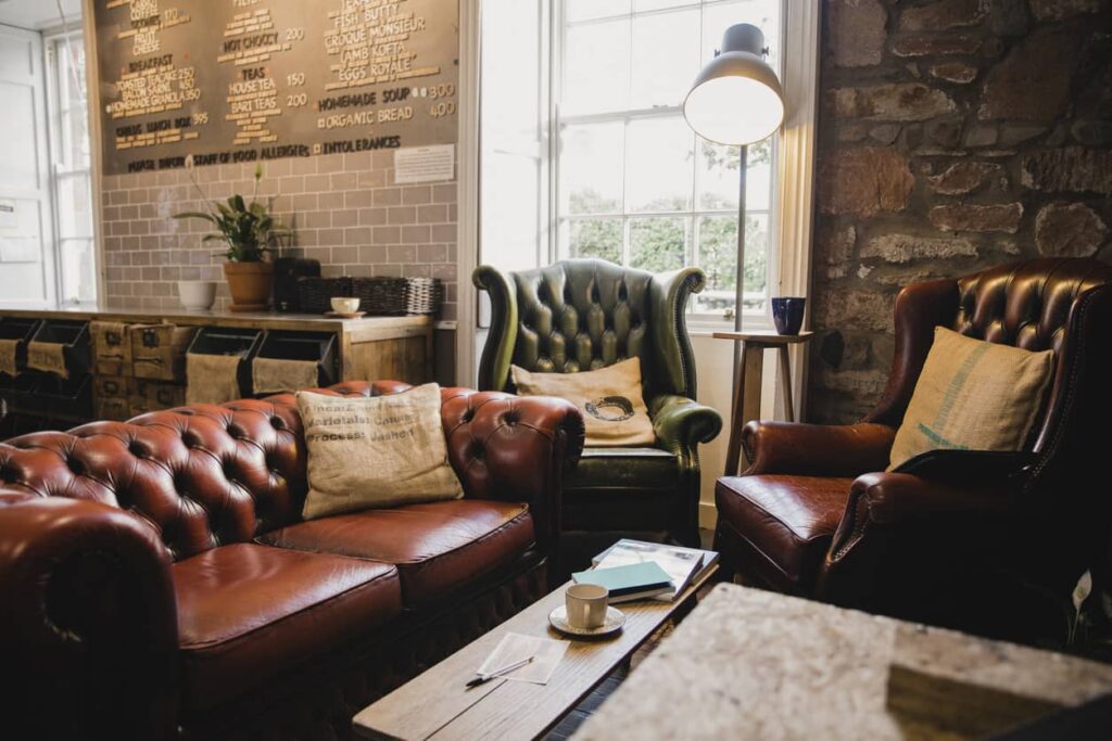 Brown leather sofa, green leather chair, and brown leather chair in a vintage coffee shop.