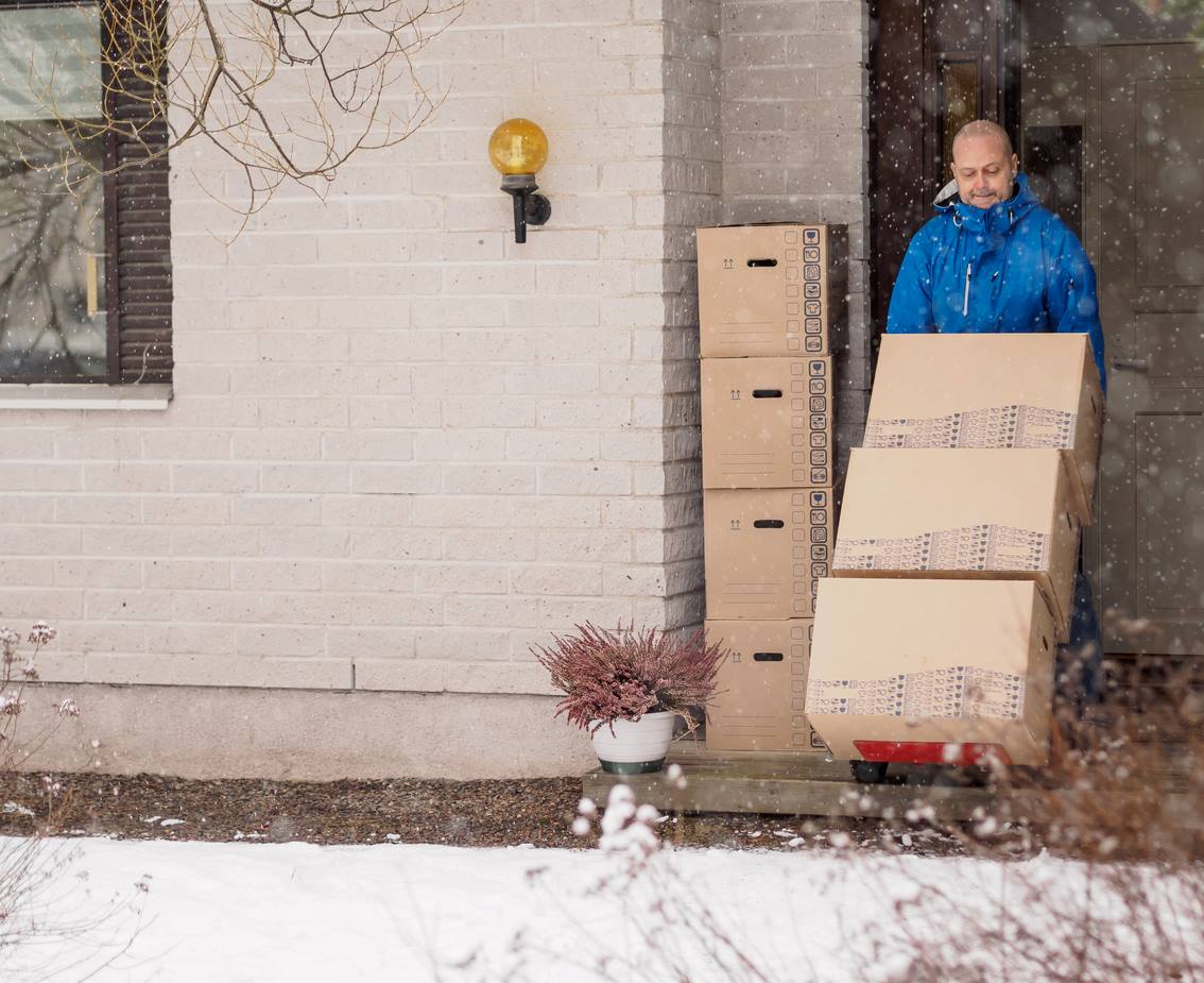Alt Text: Man moving into a new home during the winter.