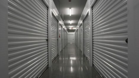 A hallway of storage units with white doors.